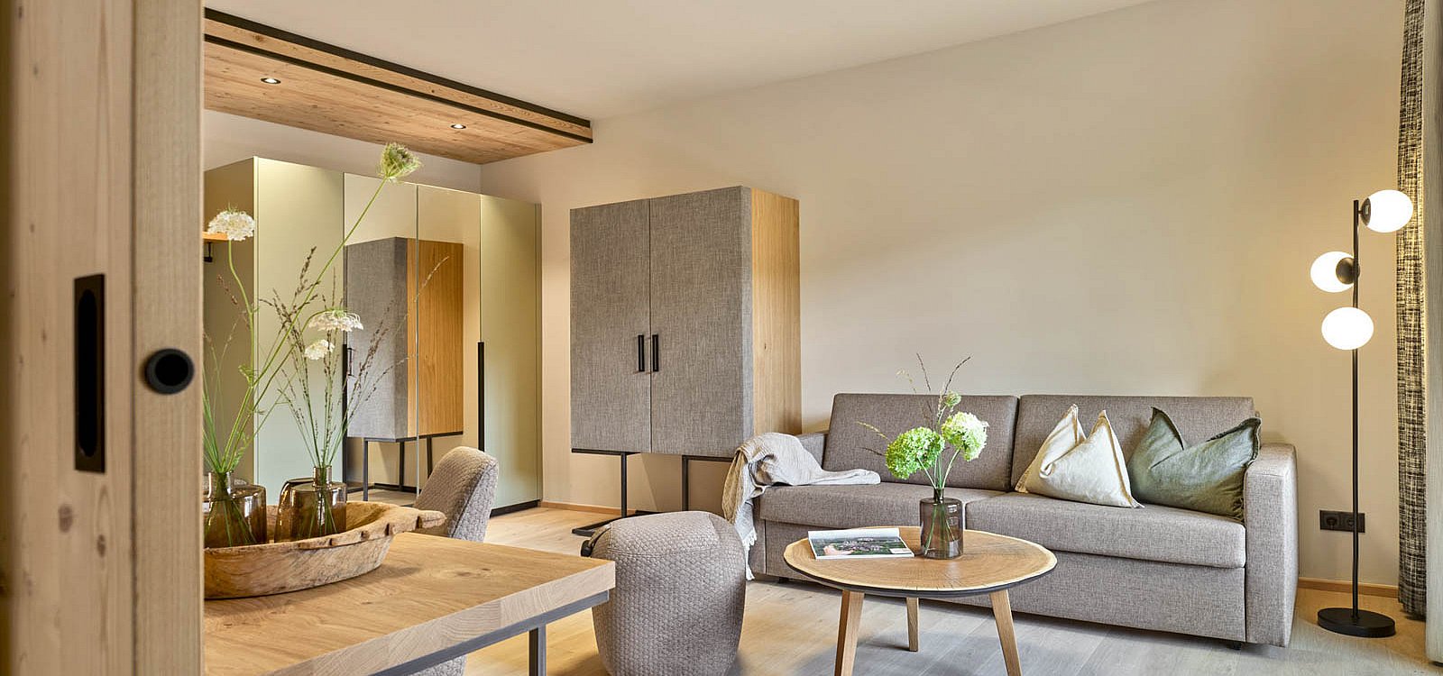 Gemütlicher Wohnraum mit Sofa, Teppich und natürlicher Dekoration