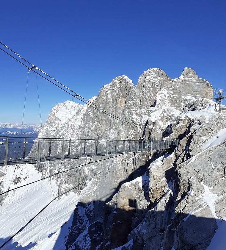 Stahlbrücke in verschneiter Bergwelt