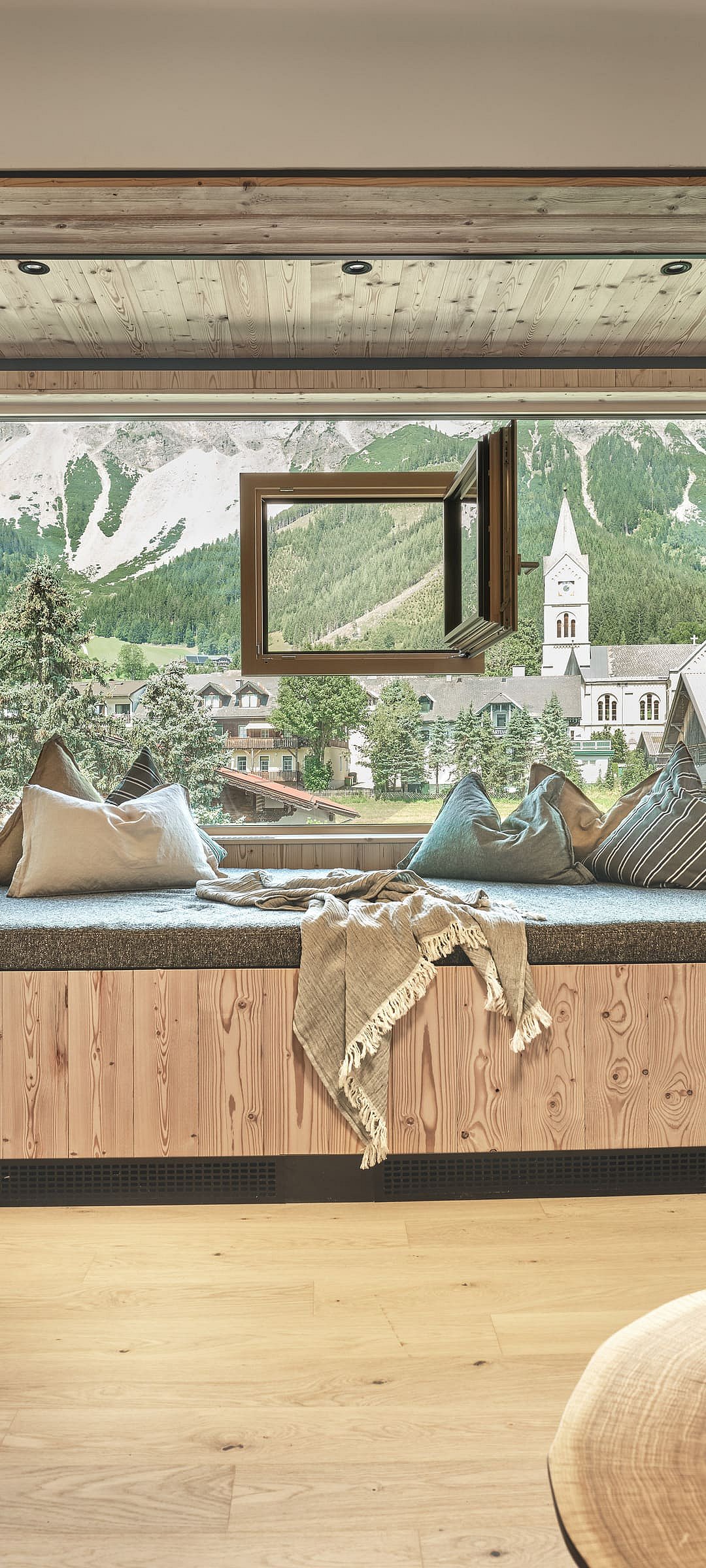 Fenster in der Glasscheibe im Hotelzimmer mit Aussicht auf das Dorfzentrum von Ramsau 